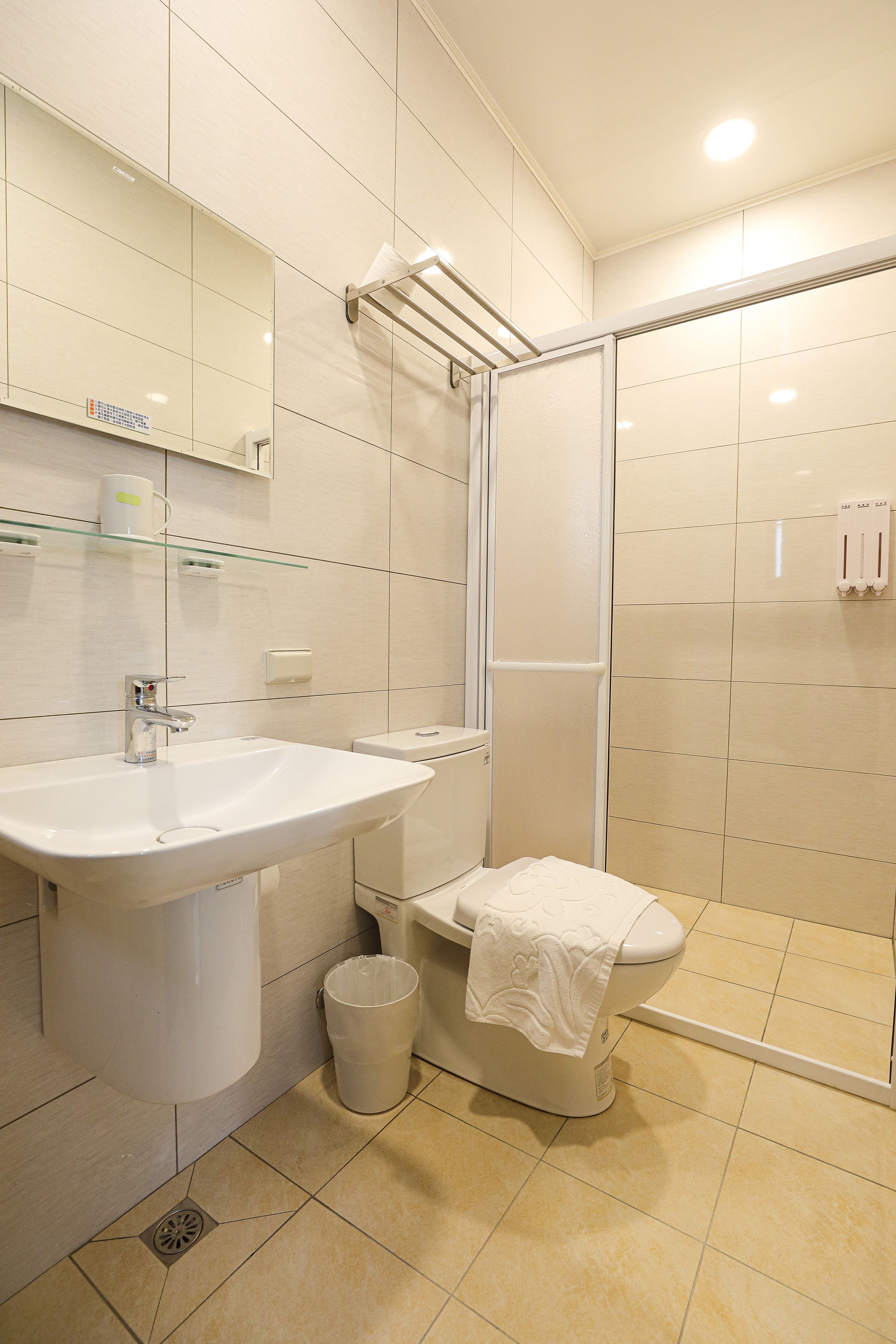 A modern bathroom with a sink, toilet, and glass-enclosed shower.