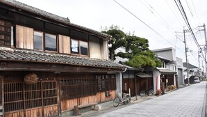 Un edificio japonés tradicional con techo de tejas, puertas correderas de madera y una bicicleta estacionada afuera.