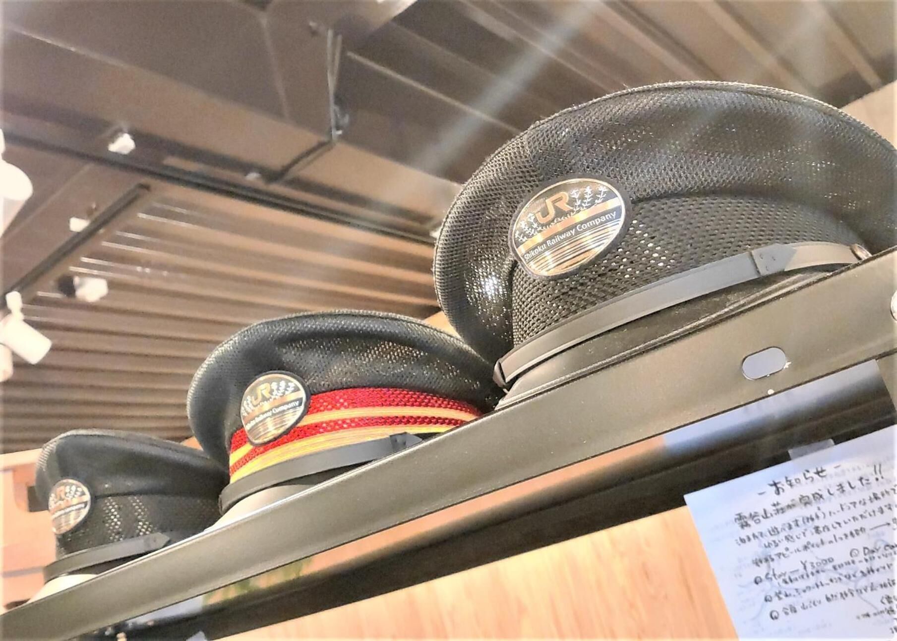 Une collection de chapeaux, chacun étant muni d’une étiquette, probablement mis en vente.