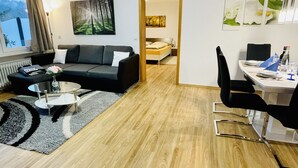 En moderne stue med sofa, sofabord og spiseplads.
