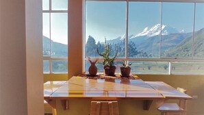 Un comedor con un amplio ventanal con vistas a un paisaje montañoso.