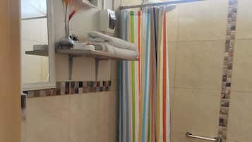 Un bagno con lavandino, wc e tenda da doccia a righe.