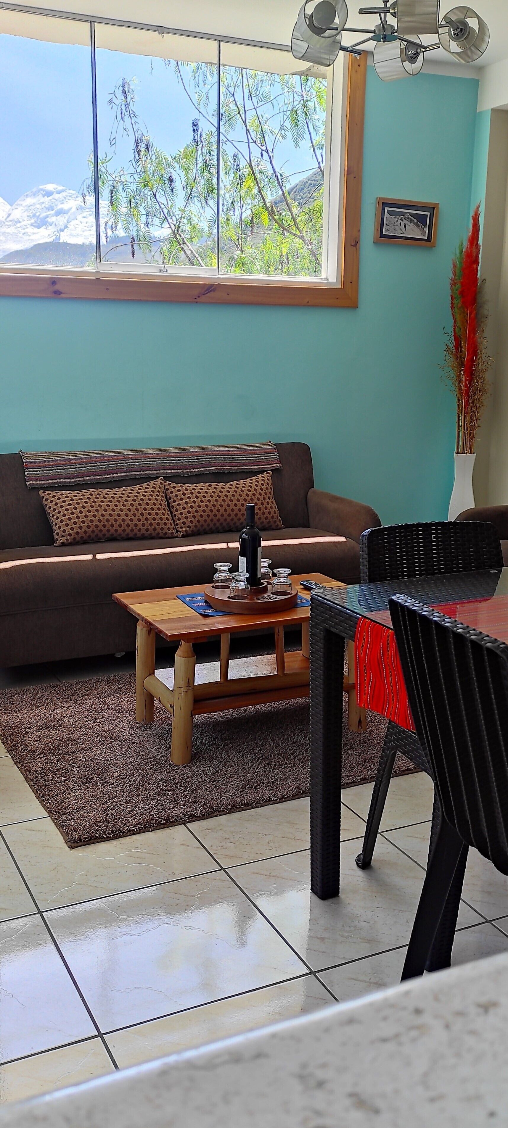 Una sala de estar con sofá, una mesa de centro y un comedor con sillas.