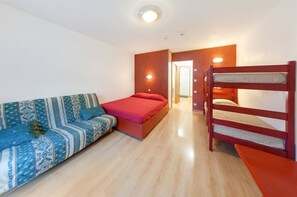 A room with a bunk bed, a sofa, and a bed.