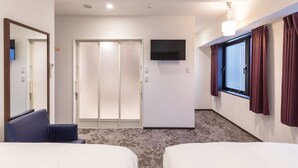 Habitación de hotel con dos camas, televisión, puerta corrediza y ventana con cortinas.
