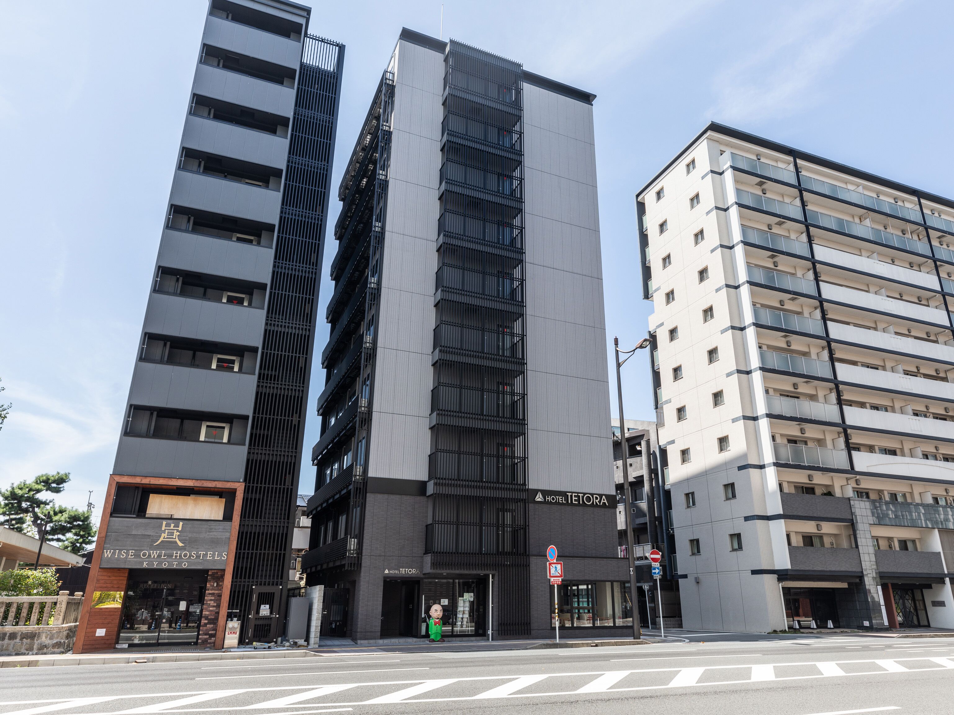 A modern hotel building with a vertical design, multiple floors, and a prominent entrance.
