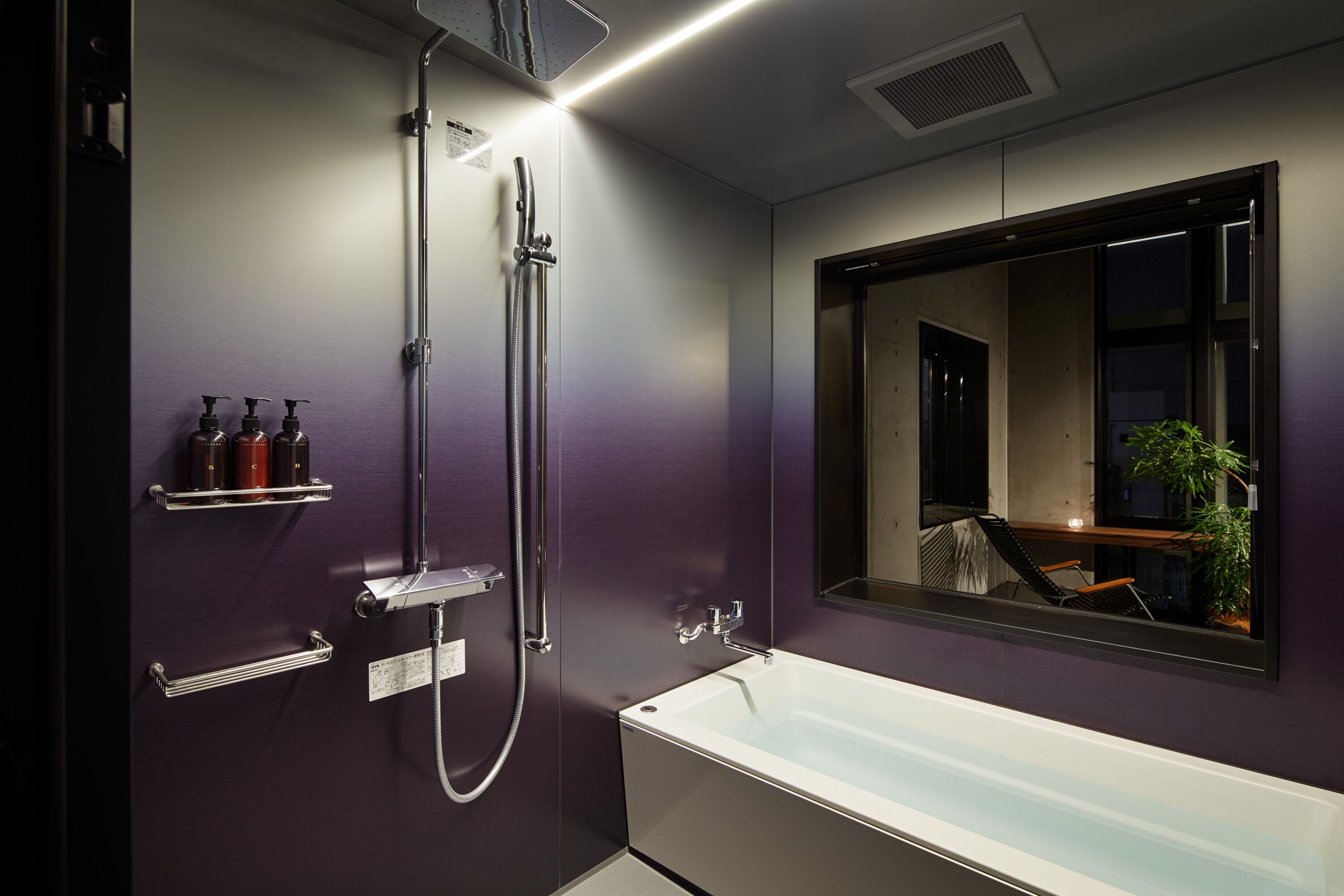 A modern bathroom with a bathtub, a shower, and a large mirror.
