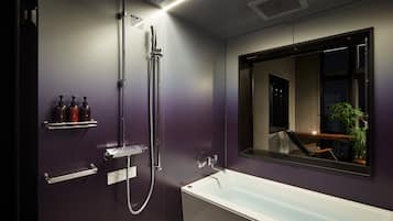 A modern bathroom with a bathtub, a shower, and a large mirror.