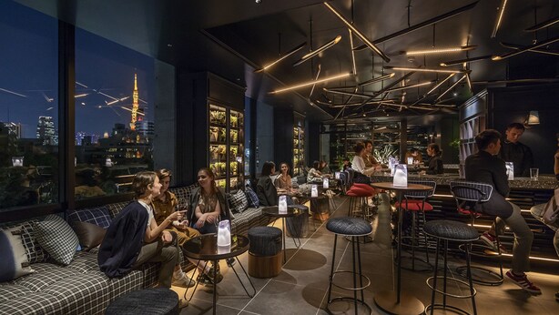 Um espaço de bar moderno com assentos e vista para a cidade.
