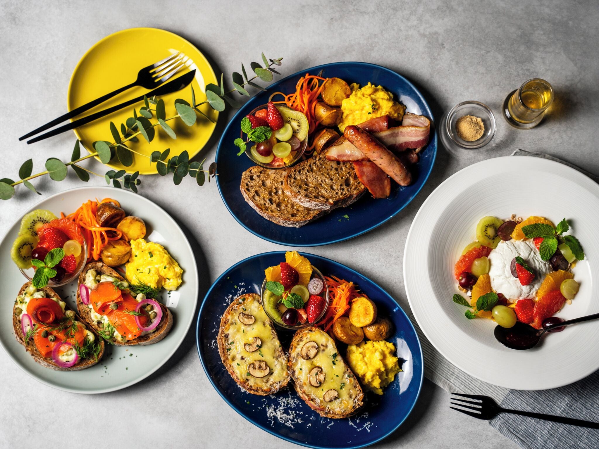 A breakfast spread with various dishes including toast, scrambled eggs, and fruit.