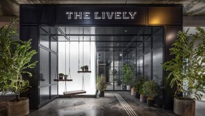 Entrada de um edifício moderno com uma placa que diz THE LIVELY.
