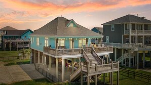A coastal building with a balcony and a staircase leading to an upper level.