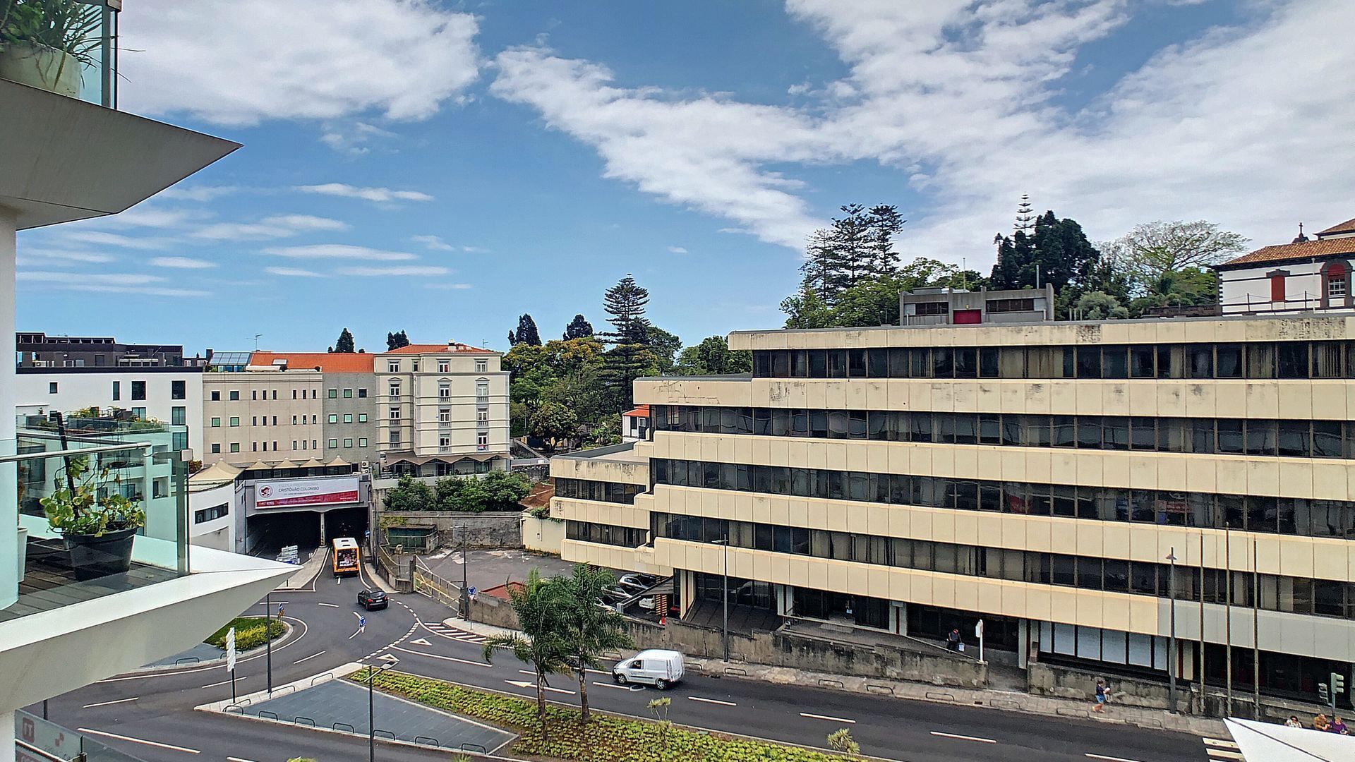 A multi-story building with a modern architectural design, featuring a central courtyard and a pedestrian walkway.