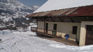 A rustic building with a wooden balcony, surrounded by snow-covered mountains. - Renovated farmhouse with panoramic views  (Le Bouchet Mont Charvin)