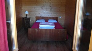 A wooden room with a bed, a nightstand, and a hanging lamp. - Renovated farmhouse with panoramic views  (Le Bouchet Mont Charvin)