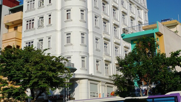 A multi-story building with a curved facade, large windows, and balconies. - Lychee Hotel (Da Nang)