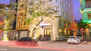 A multi-story hotel with a classic architectural design, featuring balconies and large windows. - Lychee Hotel (Da Nang)