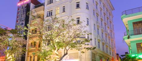 A multi-story hotel with a classic architectural design, featuring balconies and large windows.