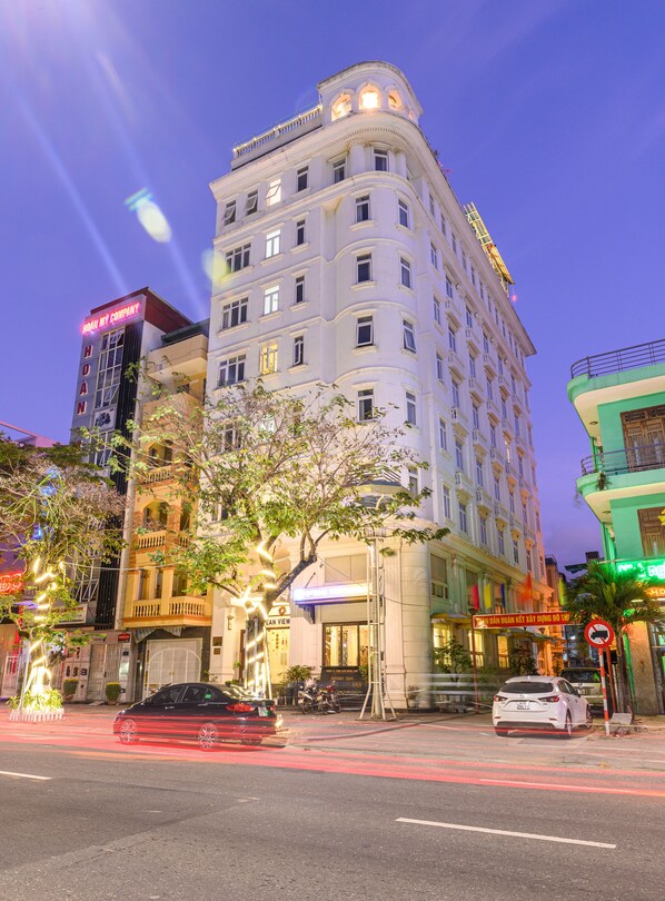 Un hotel de varios pisos con un diseño arquitectónico clásico, que cuenta con balcones y ventanas amplias.