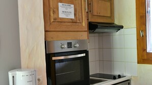 A kitchen with wooden cabinets, a built-in oven, a dishwasher, and a coffee maker. - GRAND CAP 1 - APPT 4 PERS TIGNES - PEACE AND NATURE (Tignes)