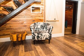 Cozy retreat with a sloped ceiling, wooden beams, and a comfortable armchair.