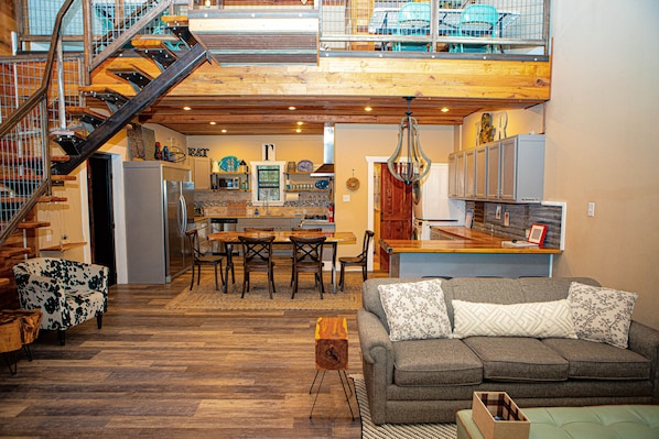 Relax in this open living area with a high ceiling, comfortable sofa, and dining space.