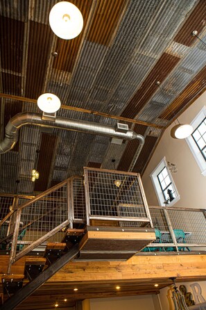 Exposed beams and industrial touches create a unique atmosphere in this open-plan space.