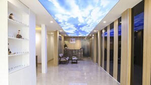 A hotel reception area with a modern design, featuring a sky ceiling, marble flooring, and a reception desk. - The Umi Hotel (Ho Chi Minh City)