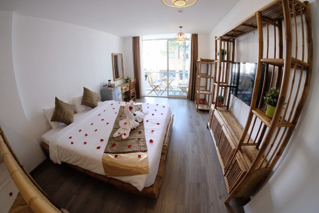 Ein Hotelzimmer mit einem großen Bett, einem Schreibtisch, einem Sessel und einem Balkon mit Aussicht.