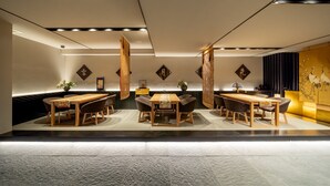 Un interior moderno con dos mesas y sillas de madera, decoración en la pared y un suelo estampado.