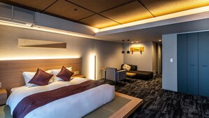 Habitación de hotel con una cama grande, un escritorio, una silla y un armario.