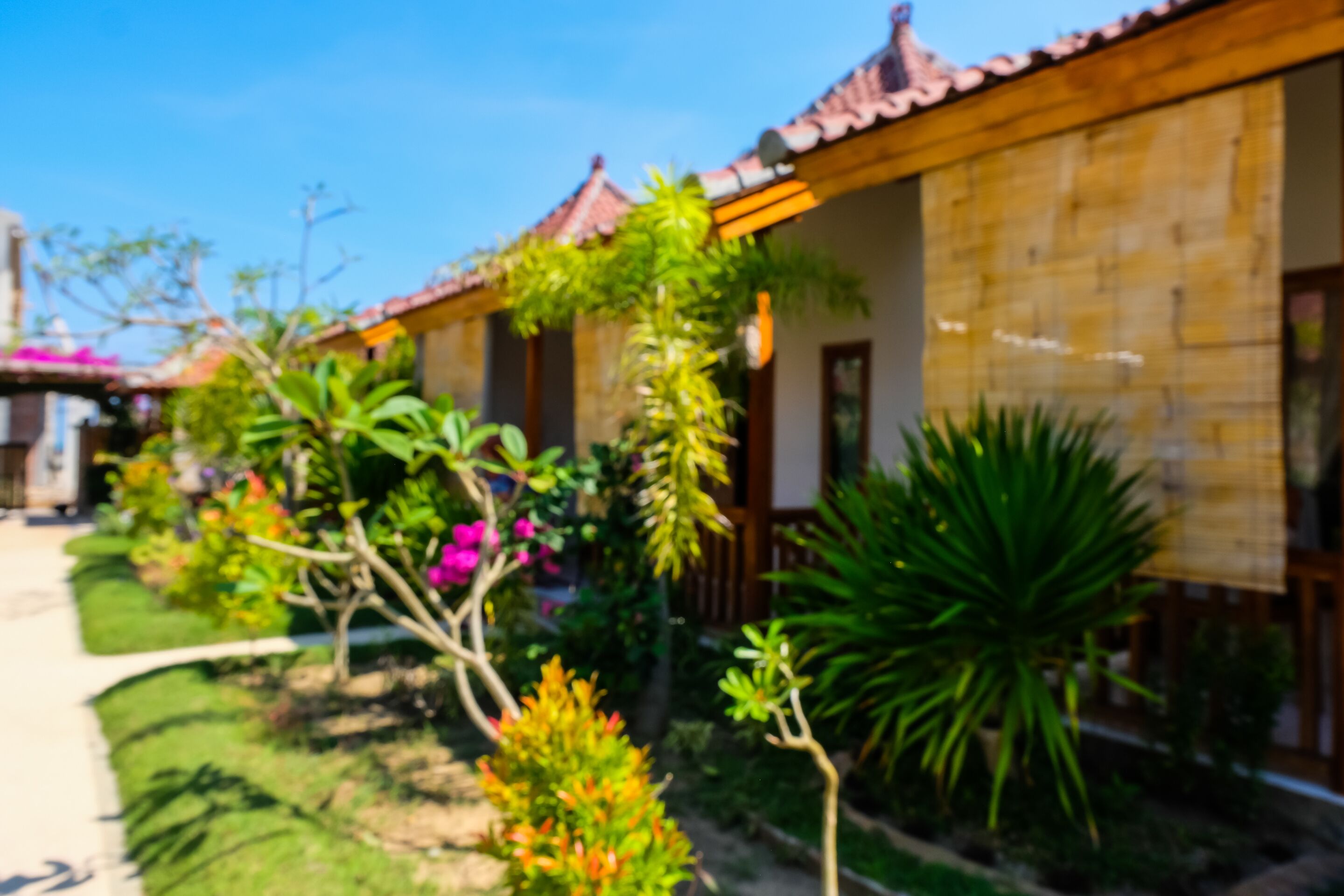 A traditional building with a tiled roof and a garden with various plants and flowers.