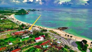 An aerial view of a coastal area with a beach, roads, and buildings. - Bungalow And Restaurant Anda (Kuta)