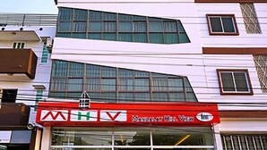 A multi-story building with a prominent red and white sign for 'Mandalay Hill View Inn'. - Mandalay Hill View Inn (Mandalay)