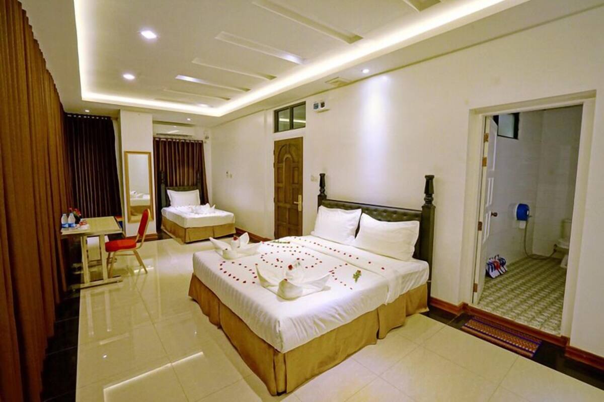 Une chambre d’hôtel avec un grand lit, un bureau et une chaise.
