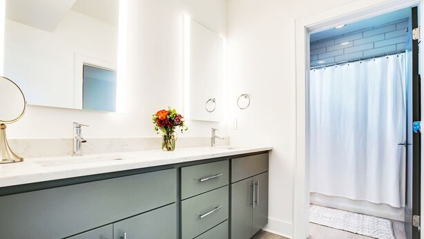 A modern bathroom with a large vanity, a mirror, and a shower curtain. - Close to Broadway · Rooftop Skyline · Walkable (Nashville)