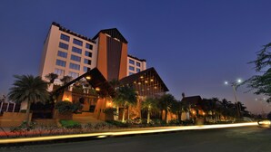 A modern hotel with a prominent tower, multiple balconies, and well-lit outdoor areas. - Sayaji Rajkot (Rajkot)