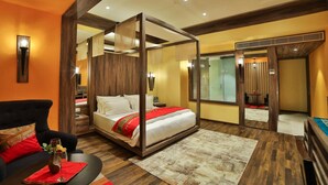 A modern bedroom with a four-poster bed, a sofa, and a dining table. - Sayaji Rajkot (Rajkot)