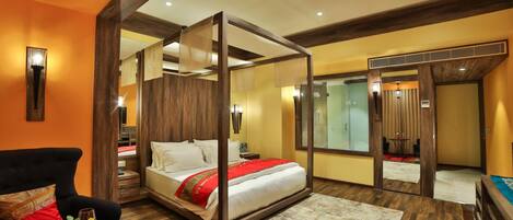 Un dormitorio moderno con cama con dosel, un sofá y una mesa de comedor.