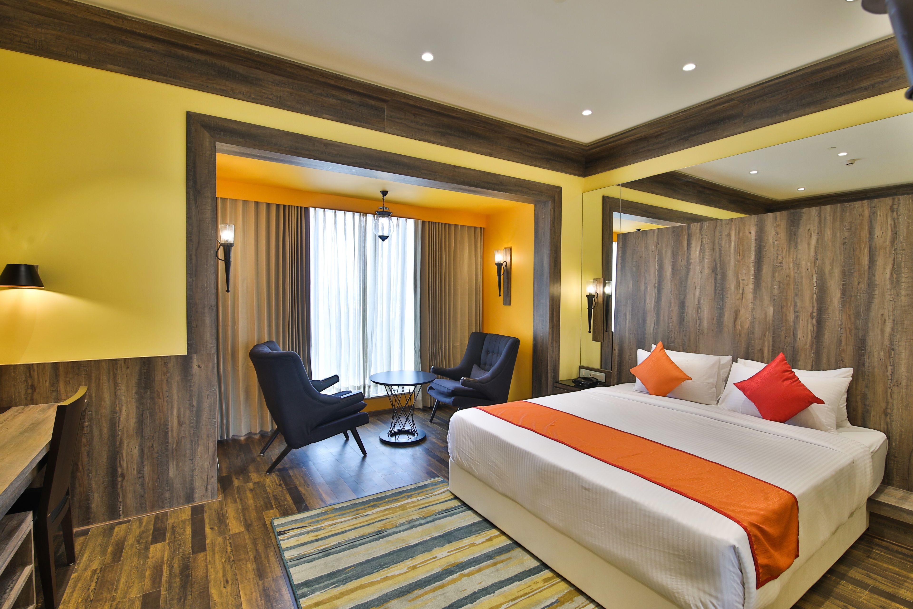Una habitación de hotel con una cama grande, un escritorio, una silla y una mesita.