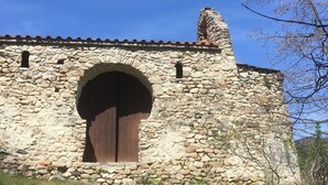 Un edificio de piedra con un gran arco de entrada y un techo de tejas rojas.