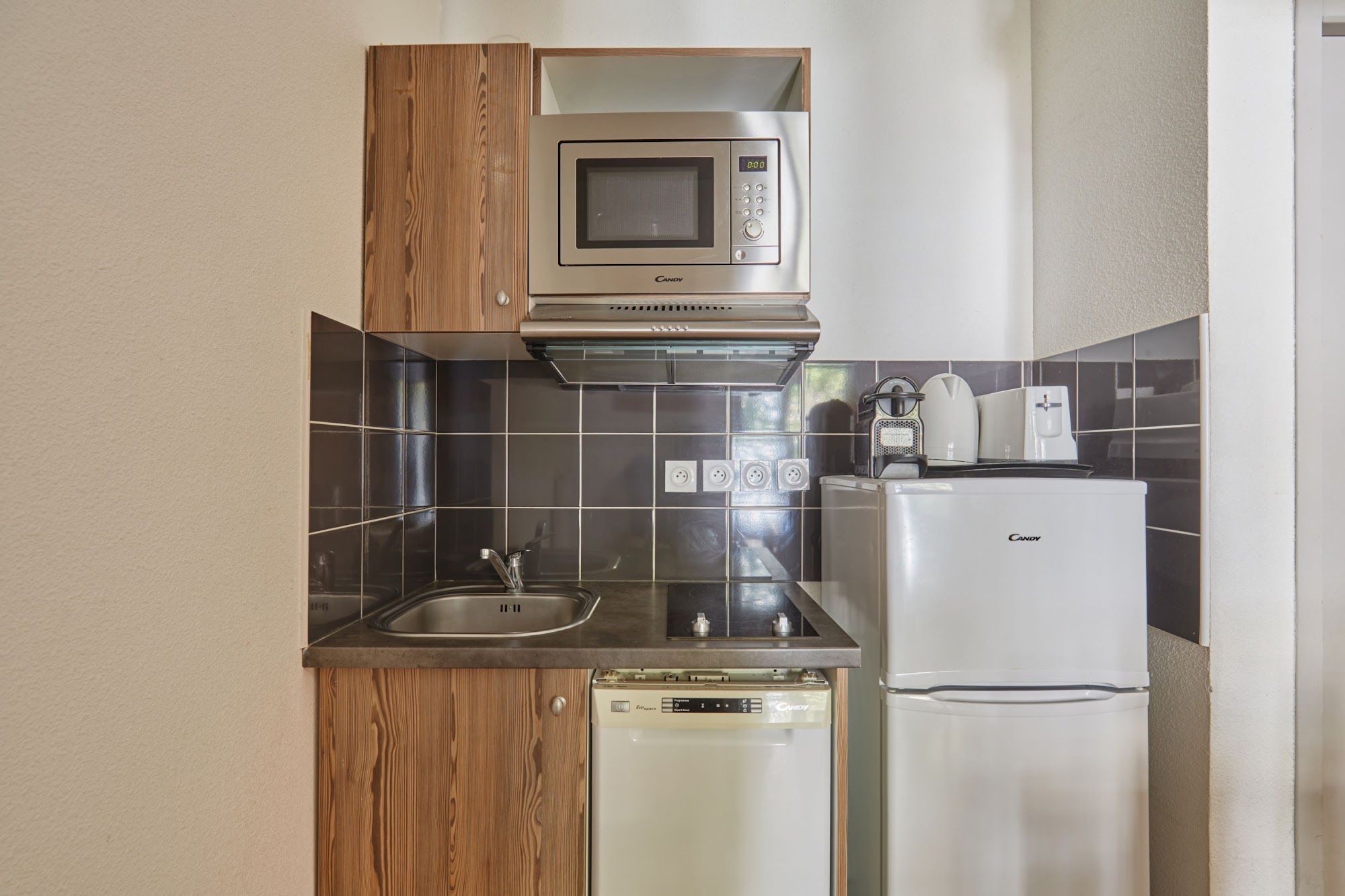 A compact kitchen with a microwave, dishwasher, and refrigerator.