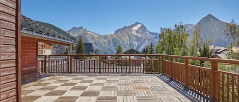 Una terraza de madera con vistas a las montañas.