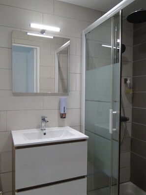Een douche, een haardroger, zeep, toiletpapier