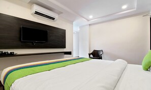 A hotel room with a bed, a flat-screen TV mounted on the wall, and a chair. - Treebo Excella (Visakhapatnam)