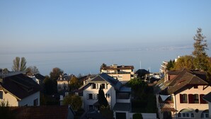 Un quartier résidentiel avec des maisons, dont certaines sont dotées de balcons, et d’où l’on peut apercevoir la mer au loin.