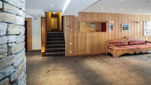 A wooden interior with a staircase, a wooden bench, and a stone wall. - Super endroit ! Appartement avec cuisinette (Tignes)
