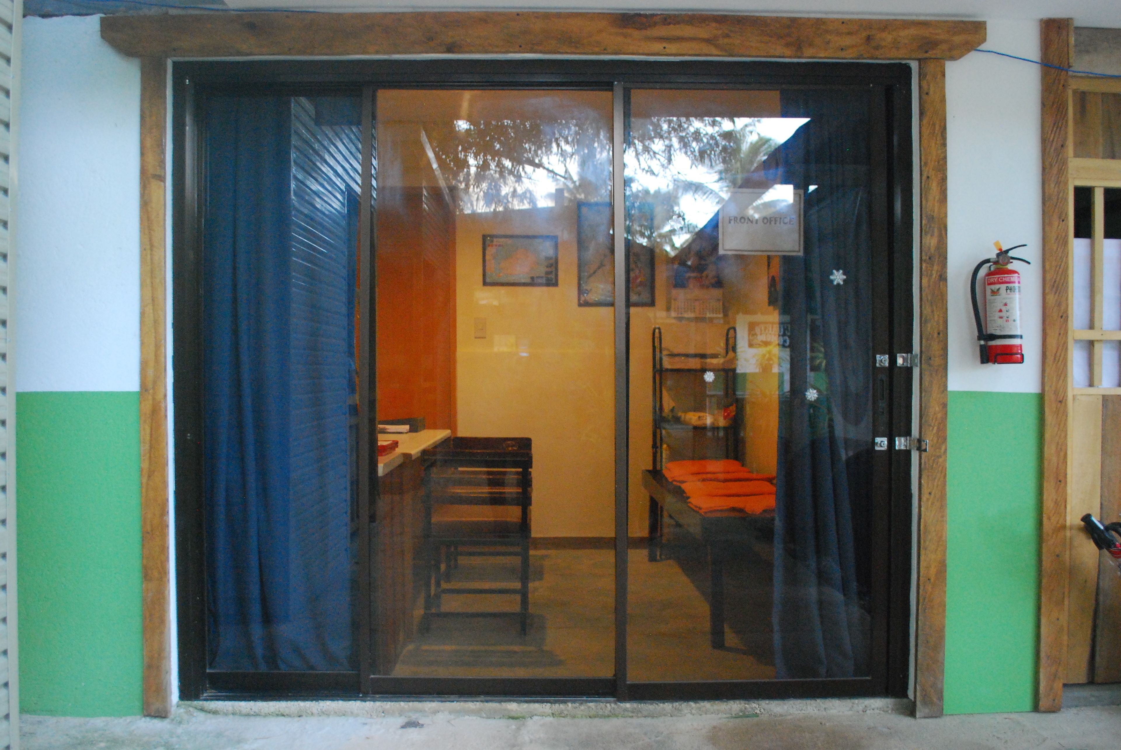 A room with a sliding glass door, a bed, a chair, and a small table.
