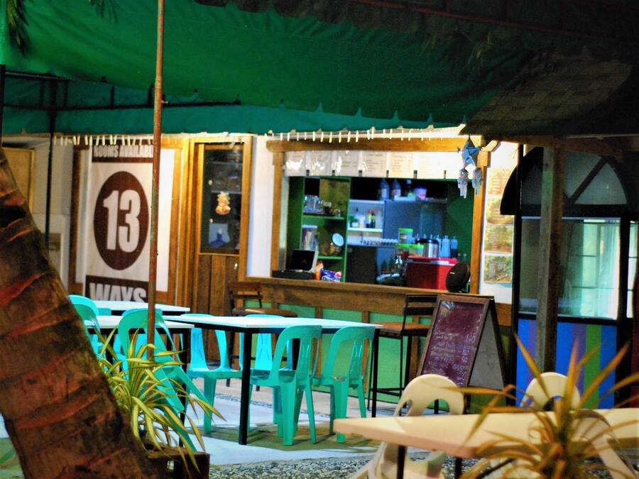 A restaurant with outdoor seating, a counter, and a sign indicating 13 ways.