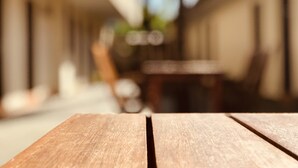 Ein Holztisch mit verschwommenem Hintergrund eines Gebäudes und einem Stuhl.